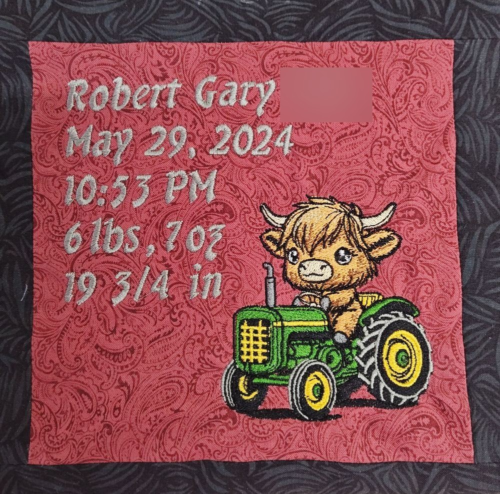 Patterned fabric patch with a personalized embroidered birth announcement and a Highland calf driving a tractor