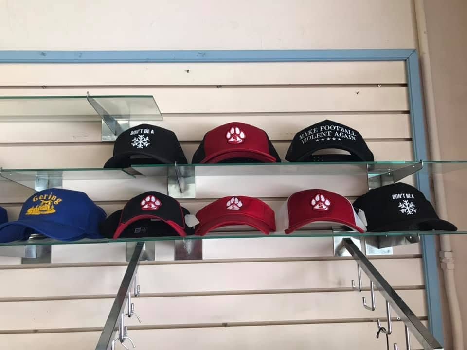 Slatwall display of finished embroidered caps with logos