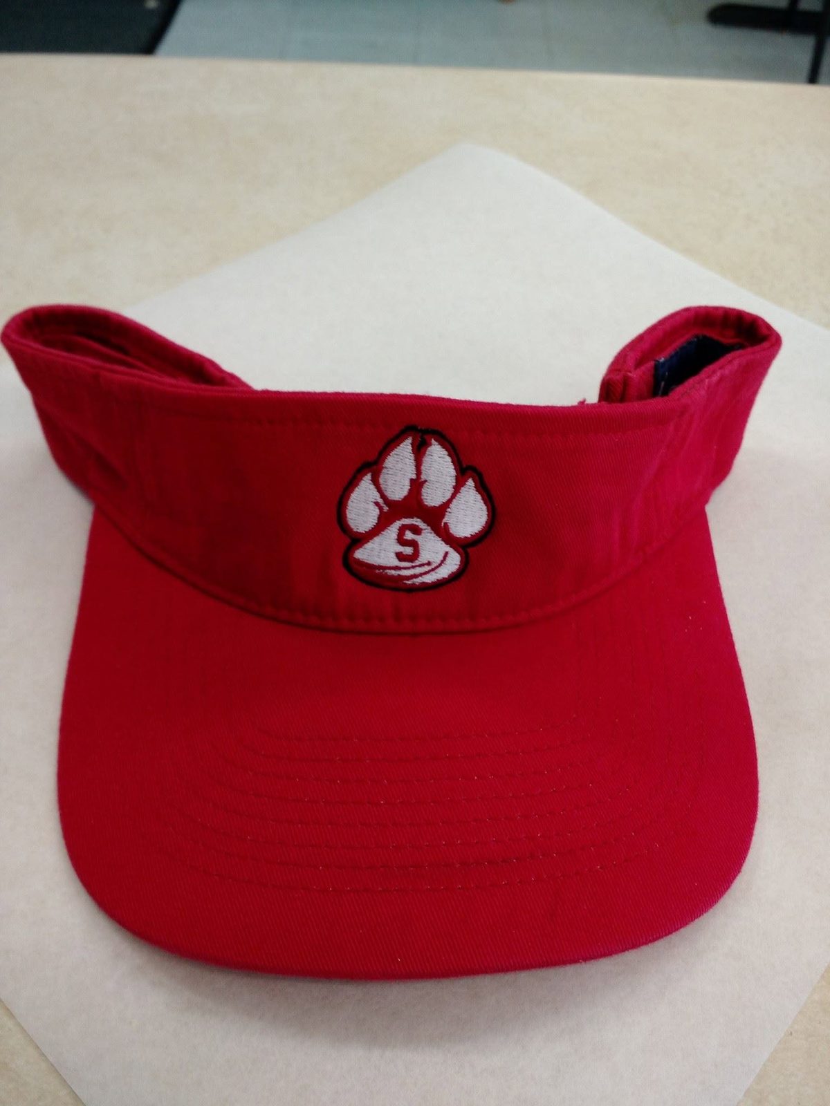 Red visor with a white paw print logo on the front